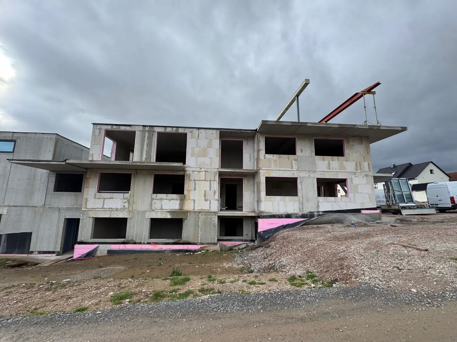 Baustelle eines Mehrfamilienhauses mit angelieferten Fensterelementen